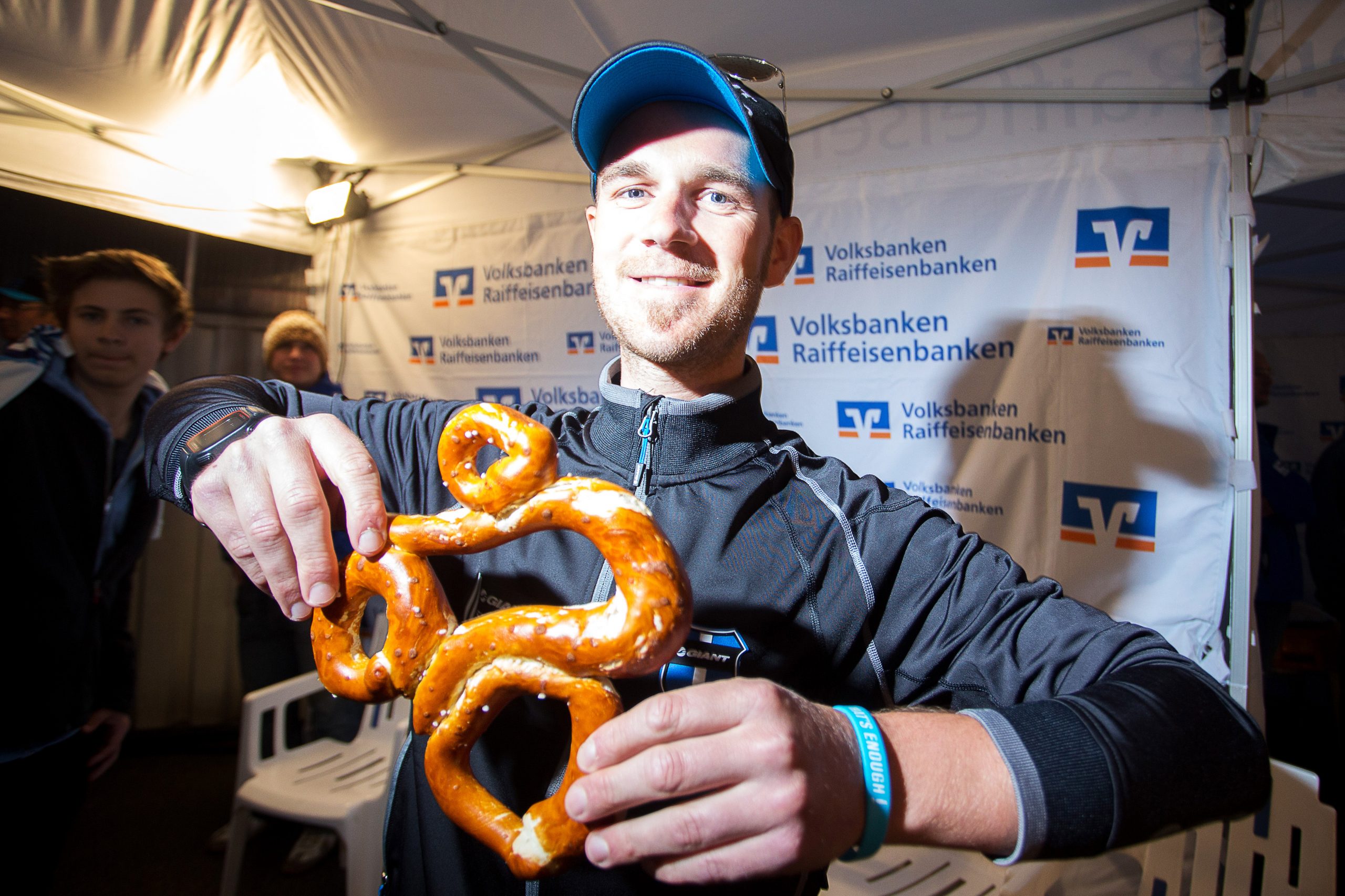 Radrennfahrer mit Rundfahrt-Brezn in der Hand